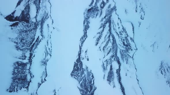 Frozen Landscape of Switzerland Mountains covered in Snow During Winter, Aerial alt