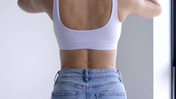 Back View Of A Slim Body Wearing Jeans And Sports Bra. Medium Shot alt