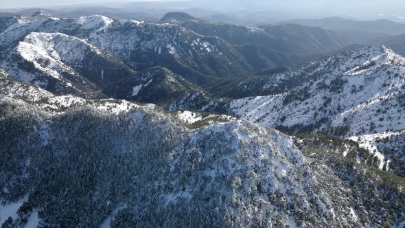Aerial view of snowy mountain peak in the sierra de Espadan, Castellon, Spain. Parallax orbit. alt