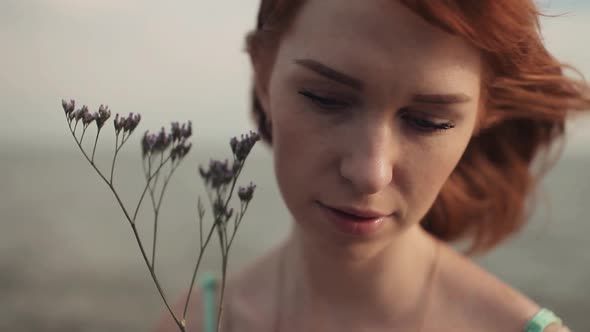 Beautiful Sexy Girl Sits on the Rocks with a Flower alt