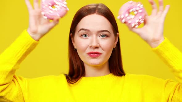 Closeup Headshot of Cheerful Smiling Young Woman Putting Pink Donuts on Eyes As Eyeglasses alt