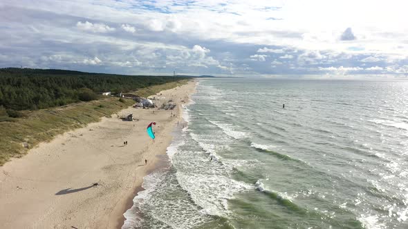 AERIAL: Surfer Rides Waves on a Sunny Day in Baltic Sea near Coast