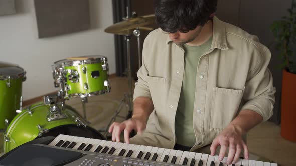Young Man Plays Synthesizer in Equipped Music Studio alt
