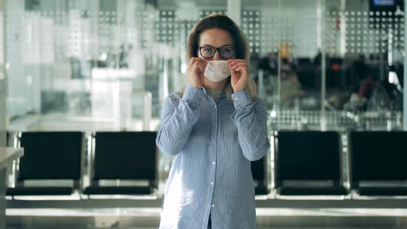 Beautiful Woman in Glasses in Putting on a Medical Mask alt
