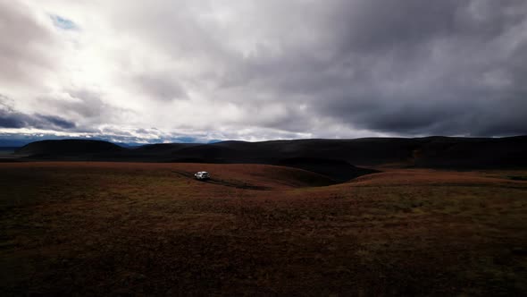 Drone Tracking Truck In Dark Mountain Landscape alt