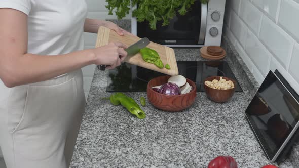 Housewife Is Getting Wooden Bowl In Kitchen Cupboard While Cooking alt