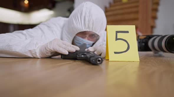 Weapon Lying on Floor with Blurred Forensic Scientist Examining ...