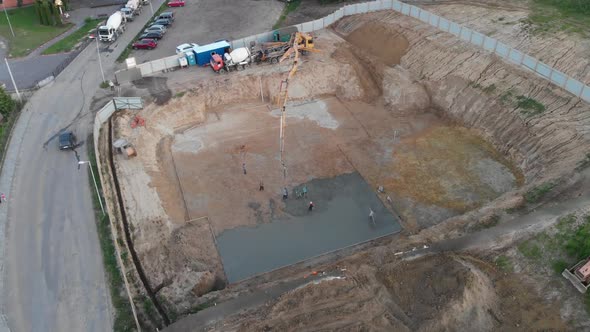 Aerial view construction workers pouring concrete at construction site basis.