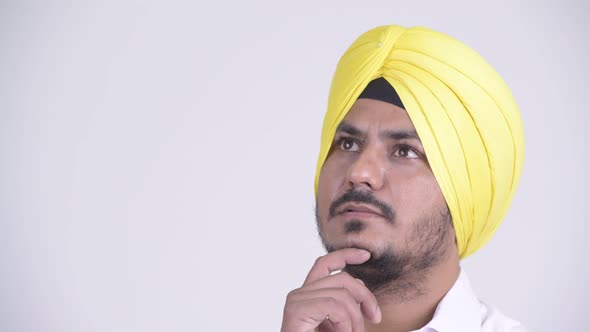 Face of Happy Bearded Indian Sikh Businessman Thinking and Looking Up alt