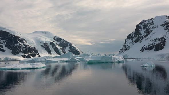 Icebergs are reflected in the water. Antarctic Nature. Majestic winter landscape. alt