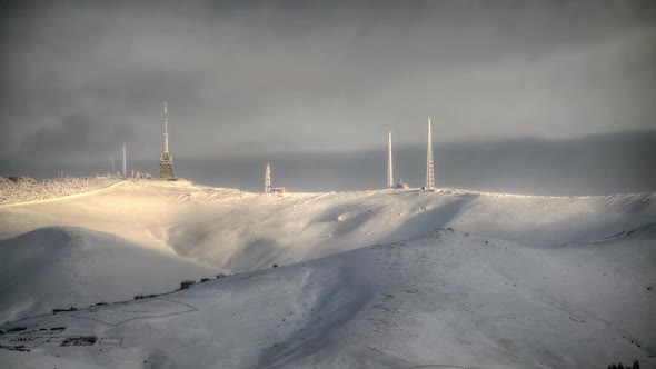 8K GSM and TV Transmitter Antennas on the Snowy Mountain Peak in Winter alt