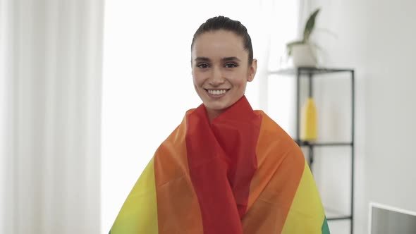 Portrait Young Woman Wearing LGBT Flag Standing at Home. She Looking Into the Camera, Smiling alt