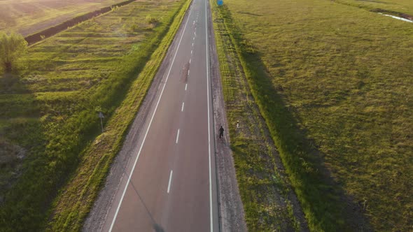 Aerial shot: single man riding bicycle by roadside