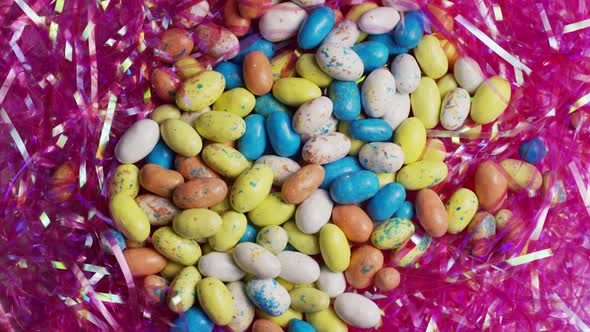Rotating shot of colorful Easter candies on a bed of easter grass alt