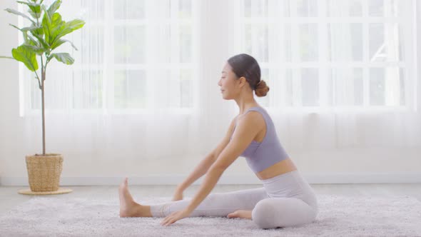 Happy Athletic Asian woman practice yoga stretching pose for stretching muscle for warm up alt
