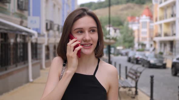Cute Girl Speaks on a Red Phone