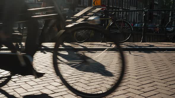 A Lot of Bicycles and Pedestrians on a Narrow Bridge in Amesterdem. In the Frame, You Can See the
