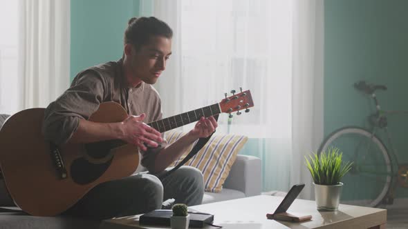 Young Man Is Learning To Play Guitar alt