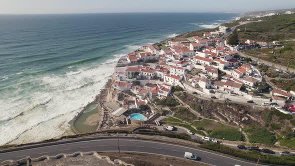 Charming Azenhas do Mar town on top of cliffs overlooking Atlantic coast. Aerial dolly out alt