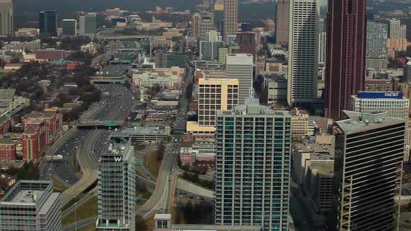 A high angle, pan shot from left to right of the Atlanta Skyline with cars on the freeway. alt