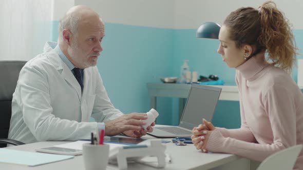 Professional doctor giving a prescription medicine to a young patient