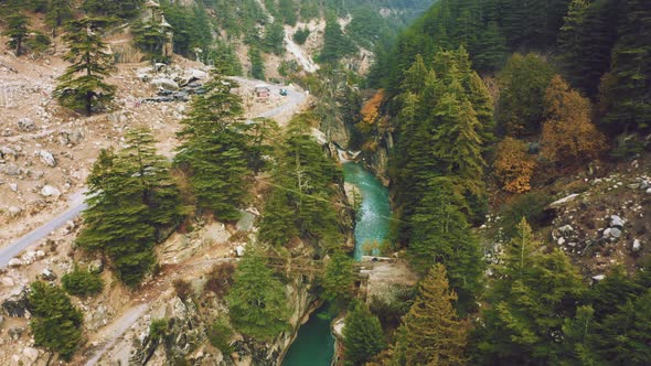 Aerial View of bridge above the Bhagirathi river surrounded by pine forest in Harshil, Uttarakhand