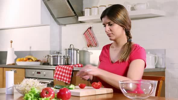 Young Adult Woman Cuts a Tomato For a Vegetable Salad 