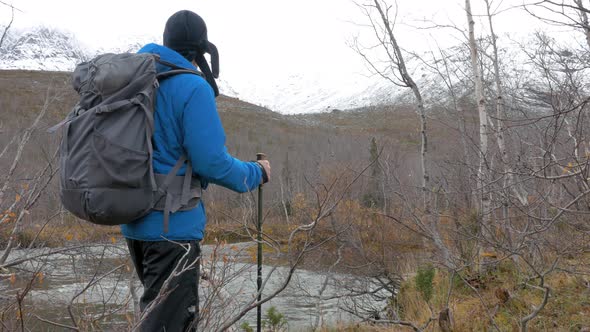 A Man with a Backpack Looks at the Mountains. Before Him Is a Beautiful Landscape. Active Life alt