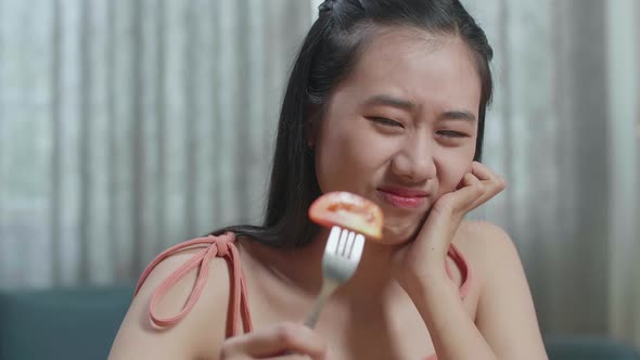 Close Up Of Asian Woman Holding Her Cheek And Shaking Her Head Due To Hating Eating Healthy Food alt