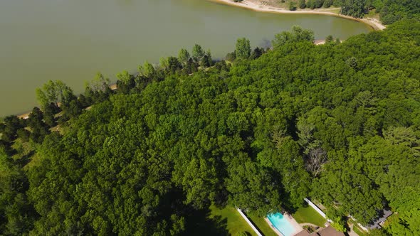 Tilting down toward homes neighboring Dune Harbor Lake. alt