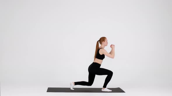 Athletic Young Female Making Jumping Lunges Exercise While Training in Studio alt
