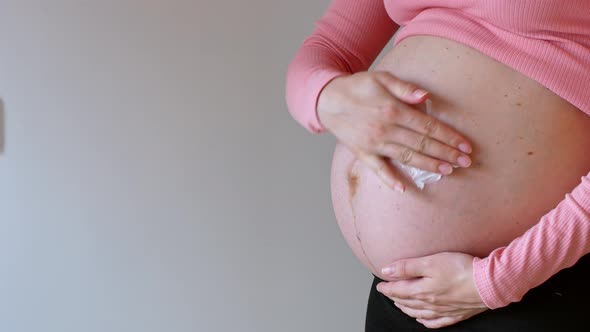 Pregnant. Skincare for the abdomen during pregnancy. Pregnant woman.
