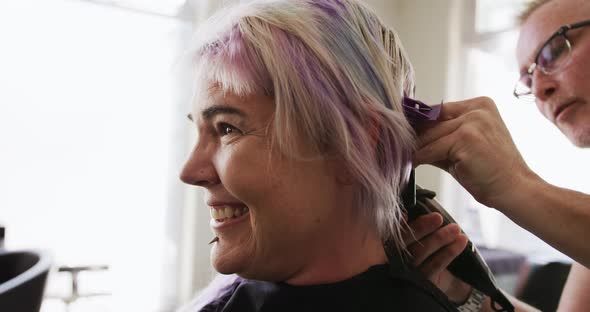 Side view woman shaving her hair at the hairdresser alt