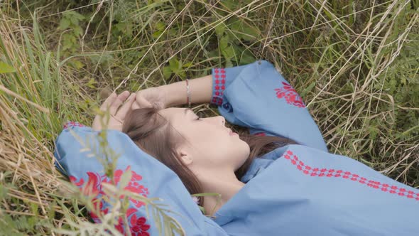 Cute Carefree Caucasian Girl Wearing Long Summer Fashion Dress Lying on the Field alt