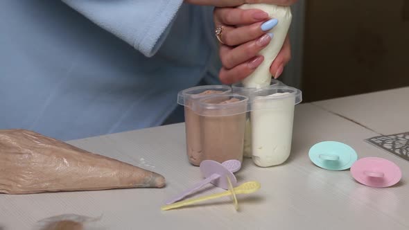 A Woman Fills An Ice Cream Mold With Buttercream. alt