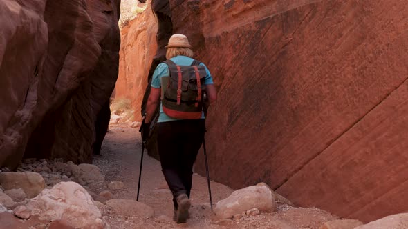 Hiker Hiking In Mountains And Gorge Enters Cave Canyon With Red Rocks alt