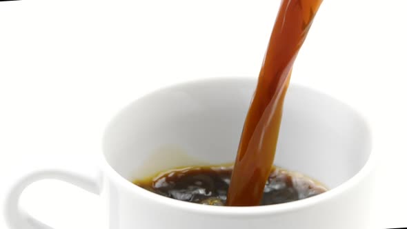 Black Coffee Pouring Into Cup on White Background in Slow Motion, Close-up