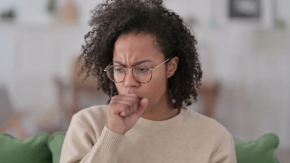 Portrait of Sick African Woman Coughing at Home alt