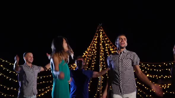 a Group of Friends Are Dancing on Stage, They Are Actively Jumping and Singing alt