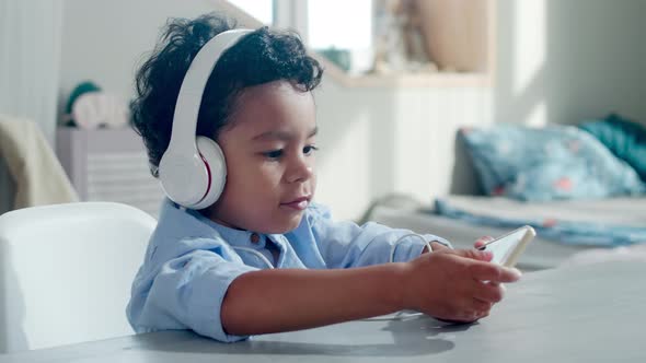 Happy African Kid Listening to Music on Smartphone