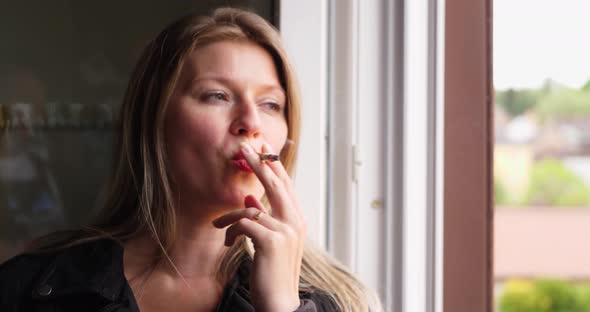 Face of a young woman while smoking a cigarette