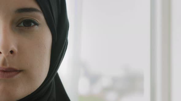 Close Up Half Female Face of Muslim Woman in Black Hijab Indoors alt