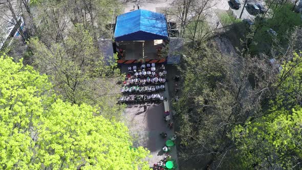 Children orchestra in city alley, aerial view alt