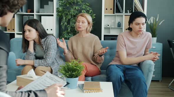 Mature Woman Mother Talking To Therapist While Unhappy Teenagers Sitting on Couch Turning Away alt