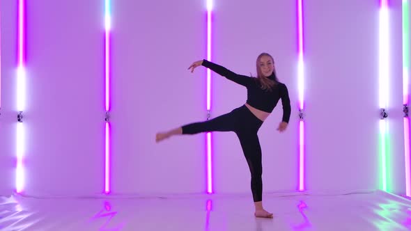 Charming Dancer in Black Leotard Performing Acrobatic Contemp Dance Elements Against the Backdrop of alt