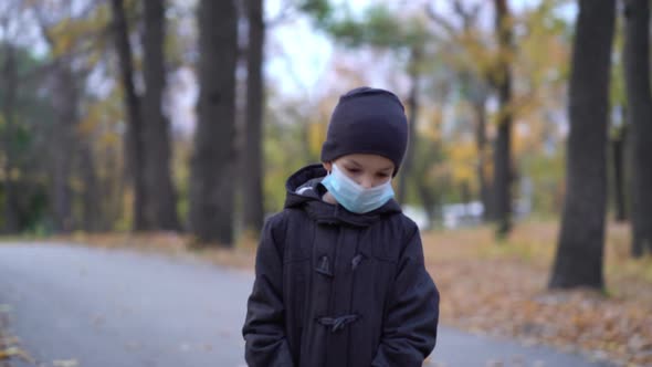 Boy in Medical Mask Walking in Park