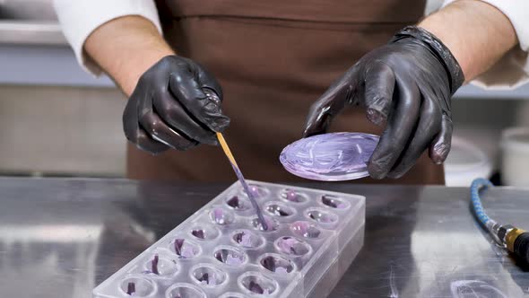 Man Pastry Chef Makes Drawings of Condurine on Chocolate Candies alt