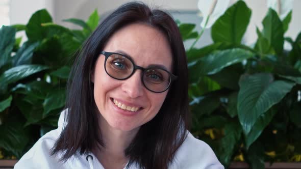 A Young Beautiful Brunette Woman of Caucasian Nationality in a White Sweater Sits in a Cozy Zone alt