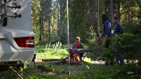 Friends Hanging Out Around Campfire Next to Their Motorhome RV alt