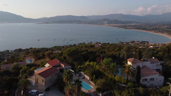 House With Swimming Pool Overlooking Calm Blue Sea In Ajaccio, Corsica, France. - aerial alt